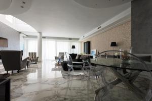 een woonkamer met een glazen tafel en stoelen bij Sapphire Luxury Villa in Iraklitsa