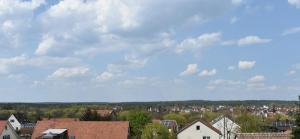 a view of a town with houses and a cloudy sky at Avenon Privathotel Schwaiger Hof in Schwaig bei Nürnberg