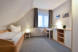 ケルピンセにあるFerienhaus Seestrand - mit Saunaのベッドとデスクが備わるホテルルームです。