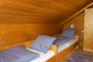 dwa łóżka w domku z drewnianymi ścianami w obiekcie Wallackhaus hütte w mieście Untertauern