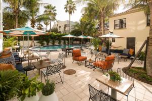 a patio with tables and chairs and a pool at Generator Miami in Miami Beach