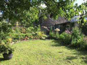um jardim com flores e um edifício de tijolos em The Hermitage em Great Torrington