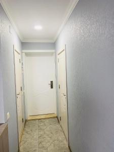 a hallway with a white door and a tile floor at sea view rooms in Batumi in Batumi