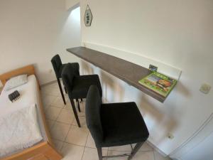 a desk in a room with chairs and a bed at Apartment Ivan-Experience 2 Bedrooms in Ljubuški