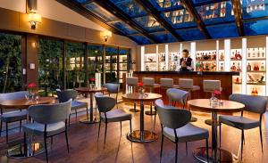 a restaurant with tables and chairs and a bar at Occidental Ankara in Ankara