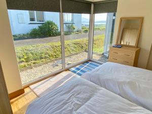 1 dormitorio con cama y ventana grande en Torrans Cottage, en Downings