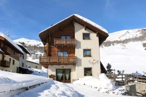 a house with a balcony in the snow at Casa Peri in Livigno