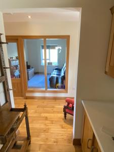 a kitchen with a large window and a living room at Torrans Cottage in Downings