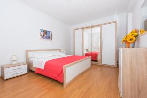 Schlafzimmer mit einem Bett mit einer roten Decke und einem Spiegel in der Unterkunft Apartment Ana Chill in Bast in Bast