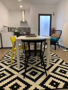 een eetkamer met een tafel en stoelen op een tapijt bij Cílio House - Duplex in Ponta Delgada