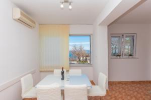 a dining room with a white table and white chairs at Apartment Ana Chill in Bast in Bast