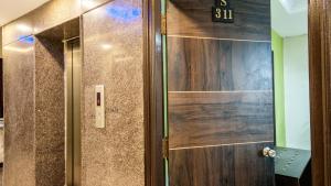 a elevator with a wooden door with a sign on it at Hotel Windsor Castle Inn Brigade Rd in Bengaluru +119 photos