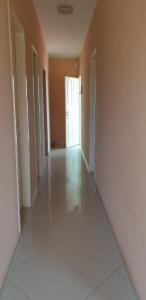 an empty hallway with a door and a room with white tiles at Casa Germania in Canoa Quebrada
