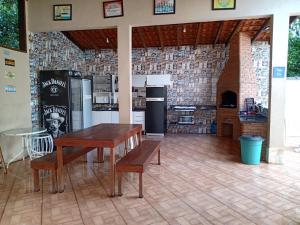 eine Küche mit einem Tisch und eine Küche mit Geräten in der Unterkunft Linda casa Condomínio Costa do Sol - Bertioga in Bertioga