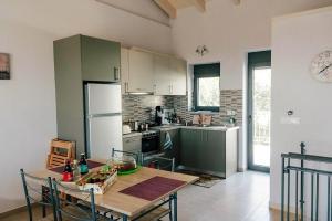 a kitchen with a table with chairs and a refrigerator at Villa "Mons & Mare" in Perdika