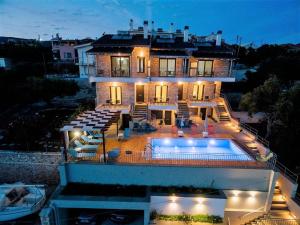 a large house with a swimming pool in front of it at Villa "Mons & Mare" in Perdika