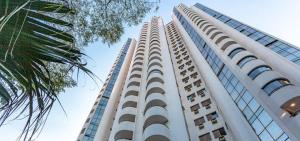 un alto edificio blanco con ventanas y una palmera en Paulista Wall Street Flat 10, en São Paulo