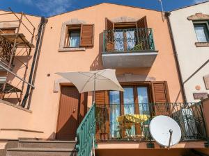 un edificio con ombrellone su un balcone di Belvilla by OYO Casa Santa Giusta a Bosa