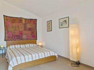 una camera da letto con un letto e un dipinto sul muro di Belvilla by OYO Casa Santa Giusta a Bosa