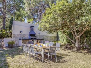 una mesa y sillas en un patio con chimenea en Belvilla by OYO Villa in Arenys de Mar with Pool, en Arenys de Mar