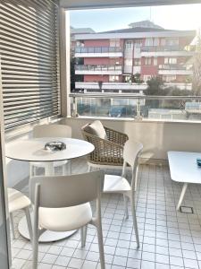 een balkon met tafels en stoelen en een groot raam bij Borgomarino 32 in Pescara