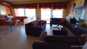 ein Wohnzimmer mit Sofas und einem Tisch sowie eine Küche in der Unterkunft Ruby's house in Chalkida