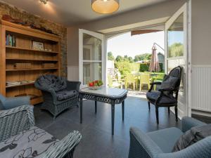 uma sala de estar com cadeiras, uma mesa e um pátio em Blissful holiday home in Sprimont with sauna em Damré