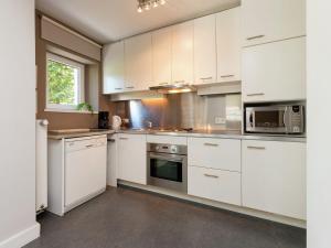 eine Küche mit weißen Schränken und Küchengeräten aus Edelstahl in der Unterkunft Blissful holiday home in Sprimont with sauna in Damré