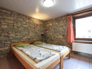 - 2 lits dans une chambre avec un mur en pierre dans l'établissement Quaint Cottage In Petite Langlire With bubble bath, à Langlir