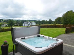 une baignoire jacuzzi installée dans une cour dans l'établissement Quaint Cottage In Petite Langlire With bubble bath, à Langlir