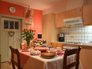eine Küche mit einem Tisch und einem Tischtuch in der Unterkunft Restored cottage in an old Ardennes farmhouse in Nimbermont