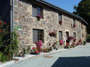 a stone building with flower pots on the side of it at Restored cottage in an old Ardennes farmhouse in Nimbermont