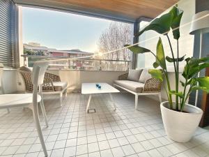 a balcony with a couch and a table and a plant at Borgomarino 32 in Pescara