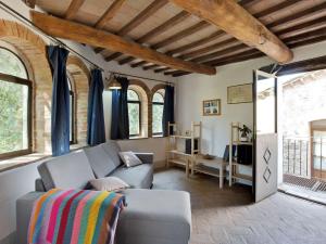 een woonkamer met een bank en een aantal ramen bij Belvilla by OYO La Cantina in Umbertide