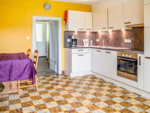 uma cozinha com paredes amarelas, armários brancos e uma mesa em Holiday Home near Ravel Cycling paths em Heuem