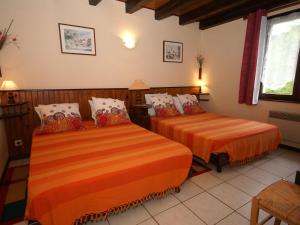 a bedroom with two beds with orange sheets at Valley View Villa in Le Menil with Private Garden in Le Ménil