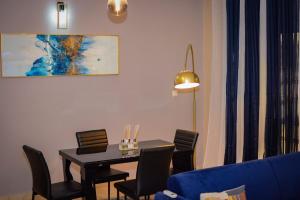 杜阿拉的住宿－Appartement Cosy 3 bonapriso，一间用餐室,配有黑色的桌子和椅子