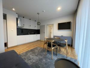 Apartament Szafir Mechelinki في ميكلينكي: مطبخ وغرفة معيشة مع طاولة وكراسي