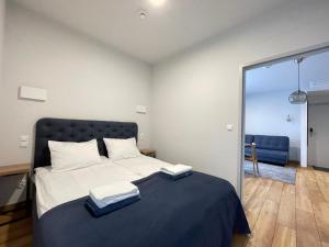 a bedroom with a large bed with two towels on it at Apartament Szafir Mechelinki in Mechelinki