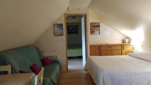 sypialnia z łóżkiem, kanapą i biurkiem w obiekcie les raseries w mieście La Chapelle-dʼAligné