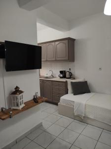 a small bedroom with a bed and a kitchen at Aitherial Summer House in Vourvourou