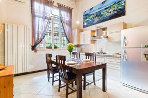 a kitchen with a table and chairs and a refrigerator at Loft di Design Porta Romana/Corso Lodi in Milan