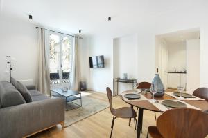 ein Wohnzimmer mit einem Tisch und einem Sofa in der Unterkunft Apartment Palais Royal by Studio prestige in Paris