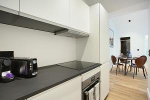 eine Küche mit einer Mikrowelle und einem Tisch mit Stühlen in der Unterkunft Apartment Palais Royal by Studio prestige in Paris