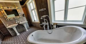 a large bathroom with a tub and a sink at Dale-Gudbrands Gard Kurs & Konferansesenter in Sør-Fron