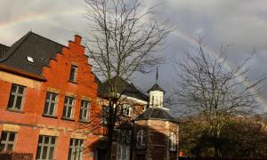 een regenboog in de lucht boven een bakstenen gebouw bij Quiet and cosy apartment near the city center of Diest in Diest