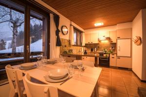comedor con mesa y sillas y cocina en Fyfauter 2, en Schwarzsee