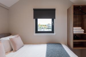 a bedroom with a bed and a window at Tattenhall Marina Floating Pods in Hargrave