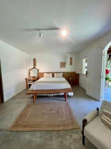 a large bedroom with a bed and a couch at Quadrado Pousada in São Miguel dos Milagres