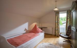Schlafzimmer mit einem Bett, einem Schreibtisch und einem Fenster in der Unterkunft Landhaus Kaiserblick in Oberaudorf